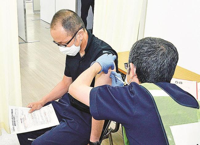 鳥取県トラック協会が職域接種を開始し、ワクチン接種を受けるドライバー（左）＝鳥取市丸山町、県トラック協会