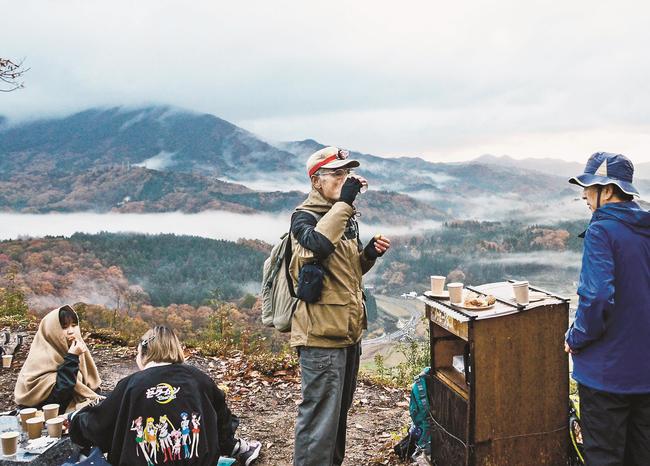 雲海や飯南町の田園風景が望める山頂付近の遺構「要害平」で朝食を味わう参加者＝島根県飯南町下来島、賀田城跡