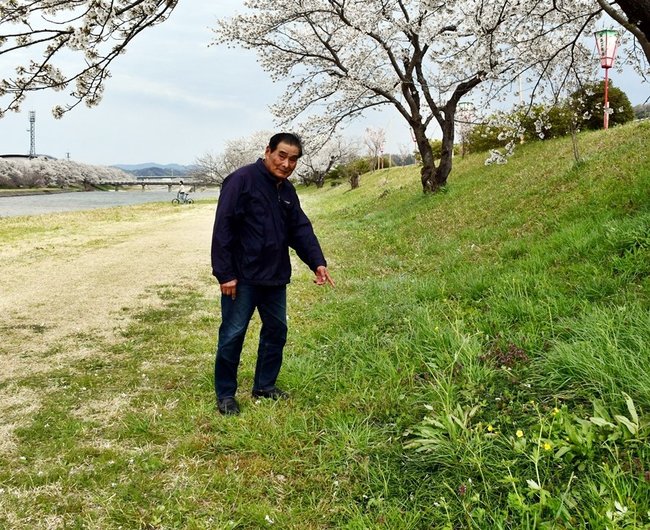 愛犬が茶褐色のものをなめた現場を指さす川津幸寛さん＝雲南市三刀屋町三刀屋