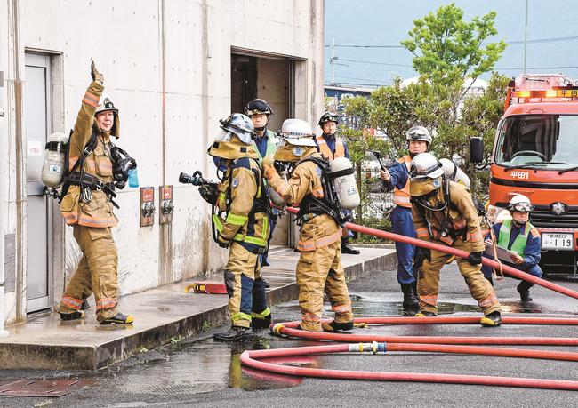 訓練で建物の内部へ入る準備をする隊員=出雲市渡橋町、市消防本部
