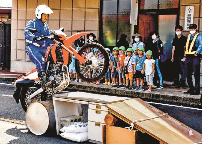 子どもたちにバイクの運転技術を披露する白バイ隊員＝大田市長久町、大田署