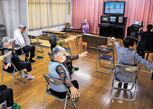 歌謡曲を歌いながら体を動かす参加者＝島根県飯南町上赤名、上赤名会館