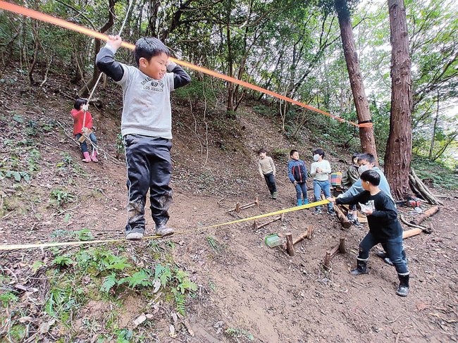 整備した山でスラックラインを楽しむ子どもたち＝松江市美保関町下宇部尾（ミホツ姫命稲穂の会提供）