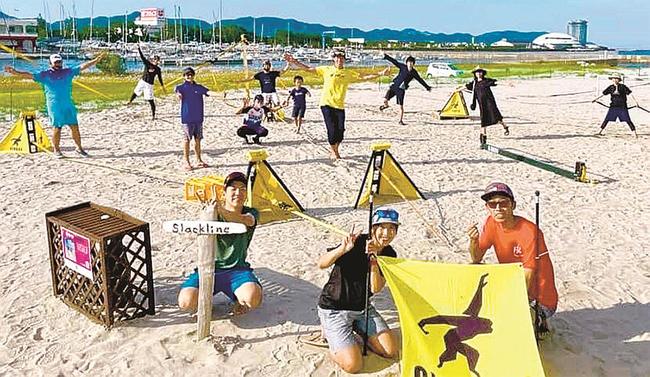 ビーチスポーツパーク境港で「スラックライン」を楽しむ来場者たち＝境港市新屋町