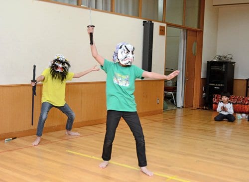 面をかぶって稽古する宮能煌大君（左）と大誠君＝松江市内中原町の市立内中原小学校