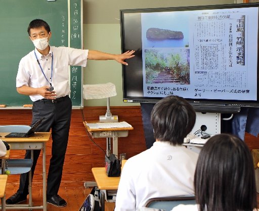 竹嶼の写真を見せ、様子を説明する大東中の大島悟校長=雲南市大東町養賀