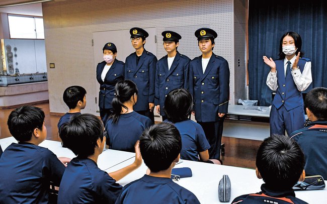 ネットやＳＮＳのトラブルを啓発する署員（右）と隠岐水産高校の生徒４人＝島根県隠岐の島町西町、西郷小学校