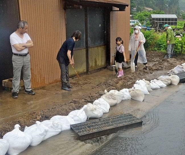土砂を撤去する住民たち＝８日午前12時30分、出雲市矢尾町
