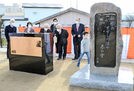 原石鼎の句碑（右）と顕彰碑を見る除幕式の出席者＝出雲市塩冶町、塩冶揚公園