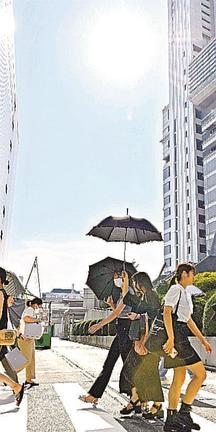 名古屋駅前を日傘を差して歩く女性たち＝27日午後