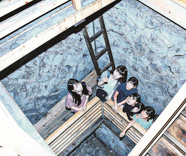 岩間から吹く冷風で涼を楽しむ来場者＝出雲市佐田町朝原