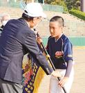 閉会式で山陰中央新報社の松尾倫男社長（左）から優勝旗を受け取る大田東の岩谷優樹副主将＝松江上乃木１０丁目、市営野球場