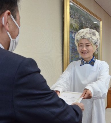 飯塚俊之市長(左)から委嘱状を受け取るロシアン佐藤さん=出雲市今市町、市役所