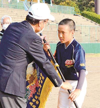 閉会式で山陰中央新報社の松尾倫男社長（左）から優勝旗を受け取る大田東の岩谷優樹副主将＝松江上乃木１０丁目、市営野球場