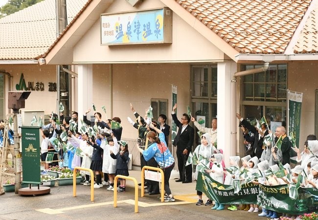 瑞風の到着を歓迎する住民や子どもたち＝大田市温泉津町小浜