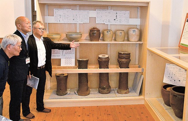 展示品と説明パネルを紹介する徳沢啓一教授（右）＝江津市江津町、甍街道交流館