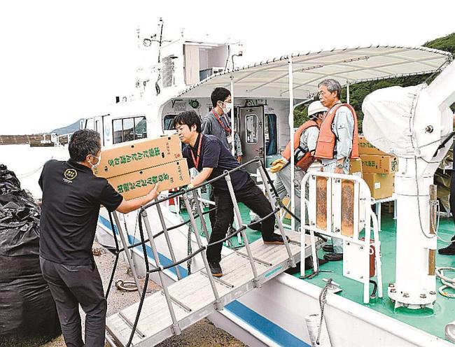 食料品や日用品などの物資を船に運び込む市職員＝出雲市大社町杵築北、大社漁港