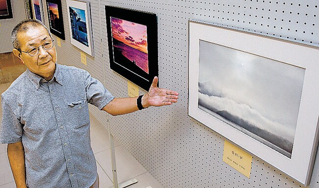 四季折々の風景を切り取った写真を紹介する篠田好人さん＝益田市常盤町、キヌヤ益田ショッピングセンター