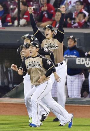 広島を破り日本一を決め、両手を突き上げて喜ぶ大谷翔平選手と日本ハムナイン＝2016年10月29日、マツダスタジアム