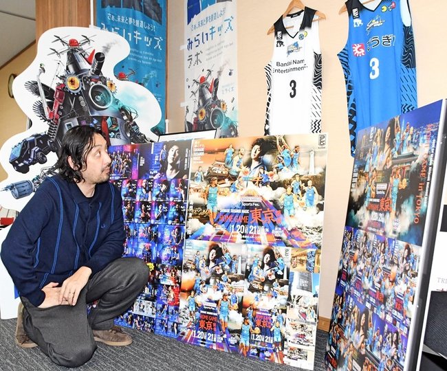 グランプリを受賞した島根スサノオマジックの宣伝広告などを眺める日下慶太審査委員長＝松江市殿町、山陰中央新報社