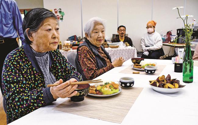 料理を味わいながら会話を楽しむ人たち＝鳥取県日野町黒坂、旧黒坂小学校