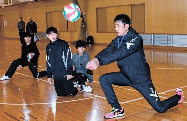レシーブの構えを指導する山本隆弘さん＝出雲市斐川町直江、斐川西中学校