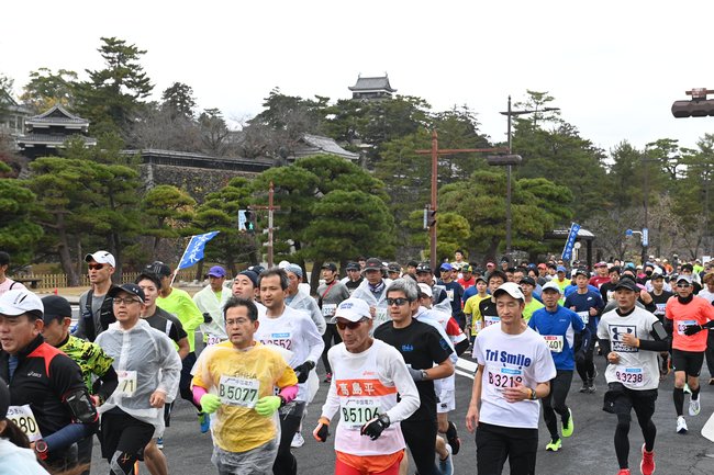 前回大会で 国宝松江城を背後に、力走するランナーたち＝２０２２年１２月４日、松江市殿町