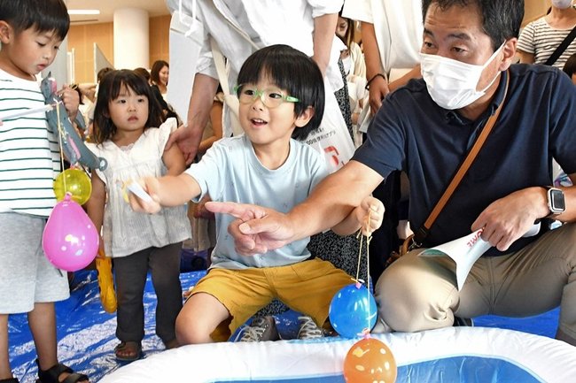 ヨーヨー釣りを楽しむ来場者=松江市学園南1丁目、くにびきメッセ