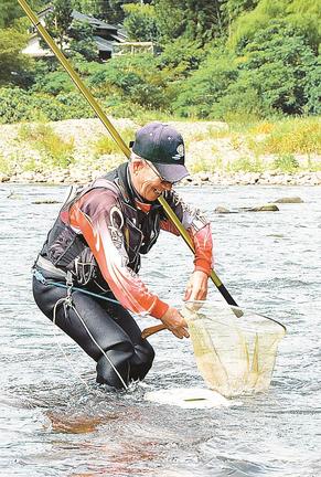 アユを釣り上げ、笑顔を見せる太公望＝出雲市所原町、神戸川