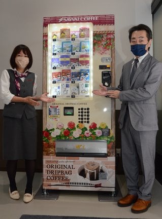 澤井珈琲の「ご当地ドリップバッグコーヒー」を購入できる自動販売機。右は同社の澤井幹雄社長＝松江市大垣町、松江フォーゲルパーク