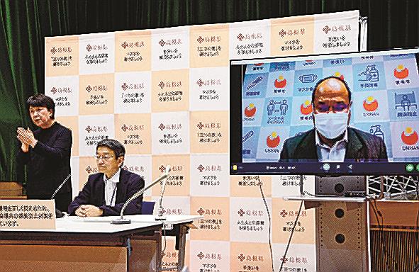 雲南市役所本庁舎で発生したクラスターについて画面越しに説明する石飛厚志市長（右）＝松江市殿町、島根県庁