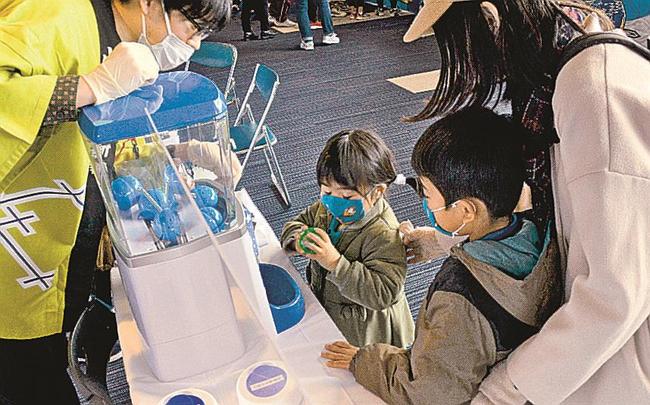 山陰中央新報社が設けたコーナーで、選手のサイン色紙などが当たる抽選を楽しむ来場者