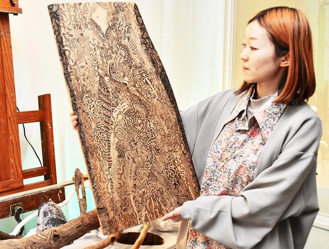 焼き絵作品「この禱」を紹介するＬｉｎ圖さん＝鳥取県大山町御来屋、名和公民館