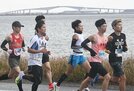 江島大橋（奥）をバックに力走する選手＝松江市手角町