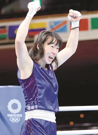 女子フェザー級準々決勝で判定勝ちし、ガッツポーズする入江聖奈。日本女子初のメダルが確定した＝両国国技館