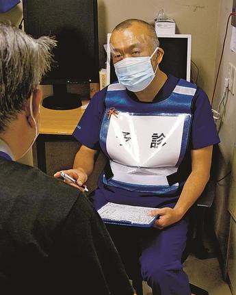 ワクチン接種前の問診を行う岡田昌彦さん=島根県川本町川本、加藤病院