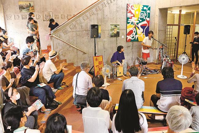 桑原宙さん率いる「ソラトラベリング楽団」の演奏に聴き入る来場者＝島根県津和野町中川、旧木部中学校