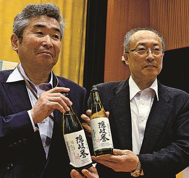 知事表彰を受けた隠岐酒造の「隠岐誉」を手にする毛利彰社長（右）＝松江市殿町、県庁