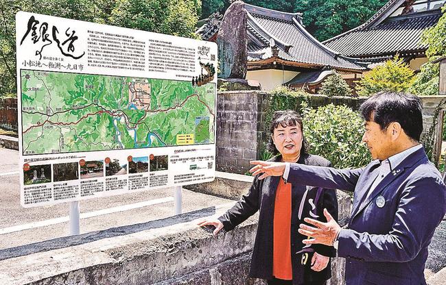 案内看板の前で嘉戸隆町長（右）から史跡の説明を受ける棗田澄子会長＝島根県美郷町粕渕