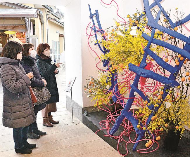 色鮮やかな作品に見入る来場者＝松江市八束町波入、由志園