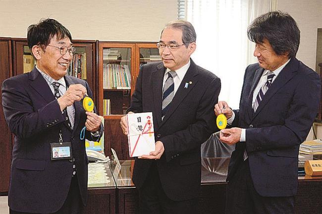 新田英夫教育長（中央）に防犯ブザーを紹介する荒木恭司社長（左）と小村健実常務＝松江市殿町、島根県教育委員会