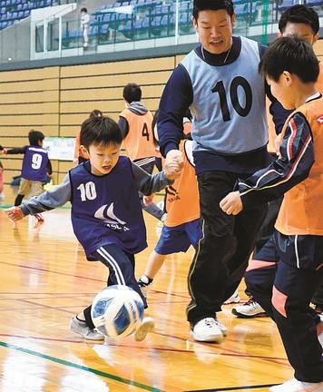 親子で手をつないでフットサルのミニゲームを楽しむ参加者＝松江市学園南１丁目、市総合体育館