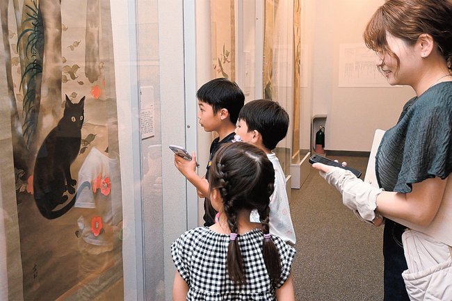 竹田霞村の作品を眺め、謎解きイベントを楽しむ親子連れ＝出雲市浜町、出雲文化伝承館