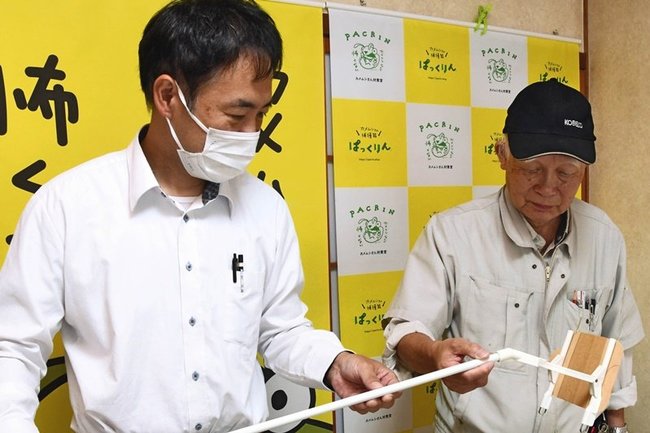 関西方面などから注文が急増しているカメムシ捕獲器「ぱっくりん」を紹介する浜村雅男社長（右）と拓志専務＝出雲市佐田町反辺