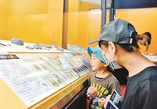 外国の文字を親子で眺める来場者たち＝松江市大庭町、八雲立つ風土記の丘