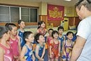 原恵介監督（右）の変顔に笑うクラブのメンバーと吾郷綺咲さん（中央奥）＝雲南市加茂町宇治、加茂Ｂ＆Ｇレスリングクラブ