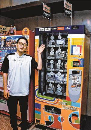 バスケットボール用品の自動販売機を紹介する社員＝松江市学園南１丁目、松江市総合体育館