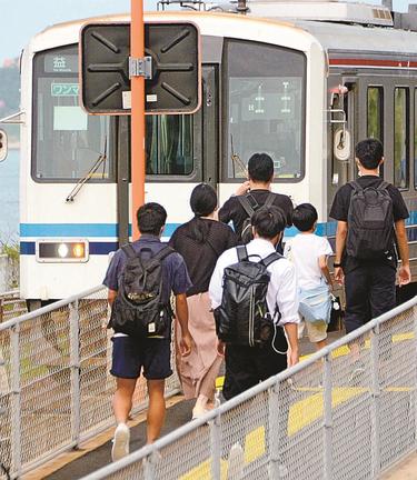 代替バスを降りて、田儀駅から西に向かう普通列車に乗り込む高校生ら＝出雲市多伎町口田儀
