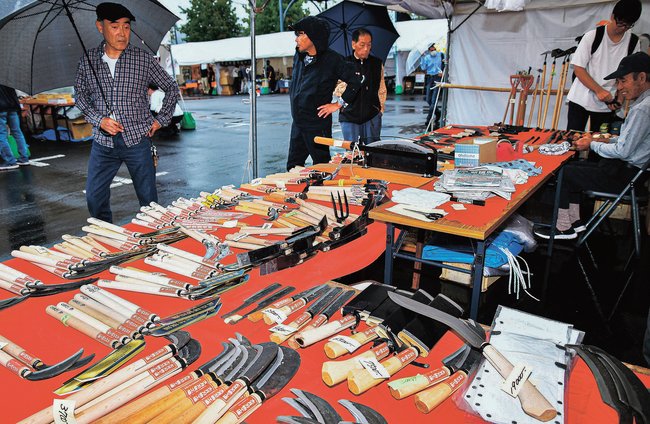 鎌やなたなど刃物を品定めする来場者＝安来市安来町、和鋼博物館