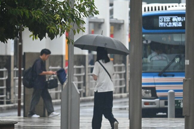 傘を差して歩く市民ら＝松江市朝日町、ＪＲ松江駅北口
